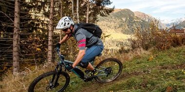 Mountain biker with helmet riding e-bike on narrow trail through Gastein’s autumn mountain landscape | © Erwin Haiden