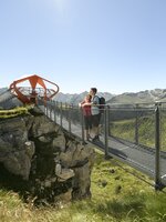 Zwei Personen genießen auf dem Felsenweg am Stubnerkogel die Aussicht zur Glocknerblick-Plattform bei strahlendem Wetter | © Gasteiner Bergbahnen, Marktl Photography