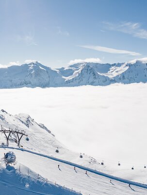 Bergstation einer Kabinenbahn und daneben stehen Skifahrer und Snowboarder und das Tal ist von Hochnebel bedeckt | © Gasteinertal Tourismus GmbH, Christoph Oberschneider