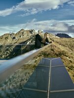 Zwei Personen blicken vom modernen Aussichtspunkt am Kieserl in Großarl über die herbstliche Berglandschaft der Alpen. | © Großarler Bergbahnen