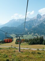 Schwarz-oranger Sessellift fährt ins Tal | © Miriam Lottes