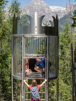Mädchen klettert eine Leiter zur Kronenrutsche hinauf, Vater und Tochter warten oben im Waldrutschenpark am Natrun. | © Roland Haschka