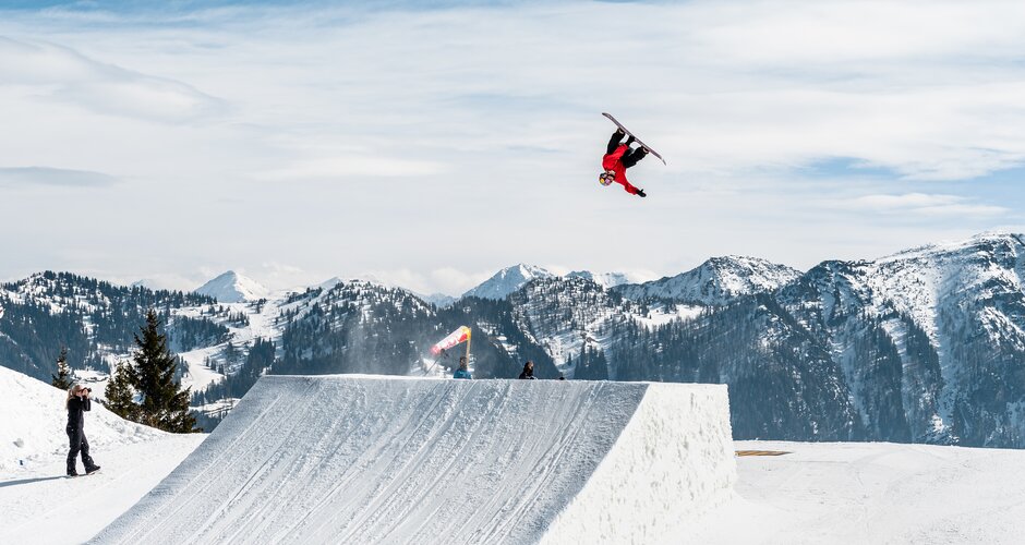Freestyler zeit Trick mit dem Snowboard bei der Großschanze am Shuttleberg 