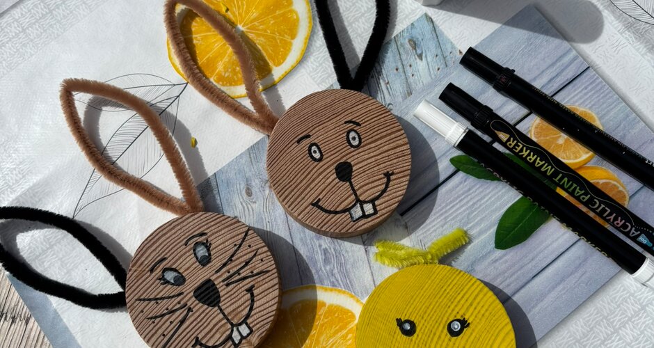 Gebastelte Hasen- und Kükenfiguren aus Karton liegen mit Stiften und Kleber auf einem Tisch beim Osterprogramm | © Planai