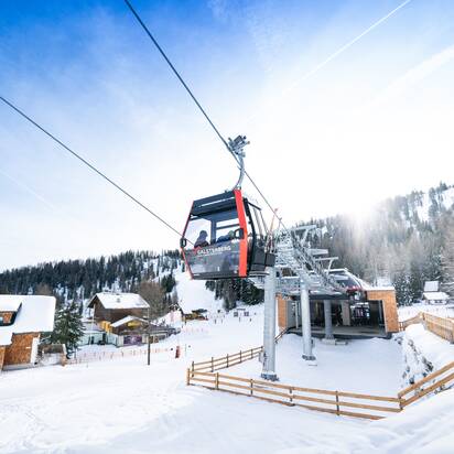 Rote Galsterberg Gondelbahn über Bergstation mit verschneiter Landschaft. | © Josh Absenger
