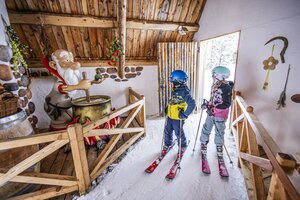 Zwei Kinder in Skikleidung betrachten eine Zaubertrank-Station im Galstiland, Galsterberg. | © Mirja Geh