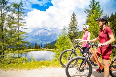 Zwei Frauen mit Mountainbikes genießen die Aussicht am Bergsee | © Hauser Kaibling
