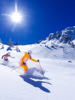 Zwei Skifahrer fahren bei Sonnenschein durch tiefen Pulverschnee am Hauser Kaibling. | © Hauser Kaibling