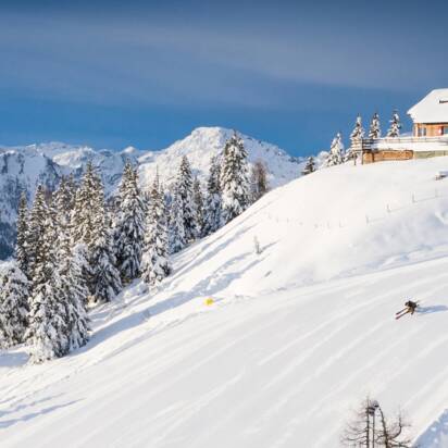 Skifahrer und Snowboarder auf verschneiter Piste mit Bergpanorama. | © Josh Absenger