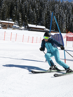 Skifahrerin im blauen Anzug fährt durch einen Slalomparcours auf der Planai, während sie eine Stange knapp umkurvt. | © Herbert Raffalt