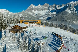 Aerial view of the snow-covered mountain station of the Rittisbahn and a ski hut with playground
