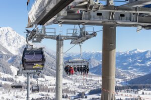 People ride chairlifts and gondolas over snowy landscape at Rittisberg.