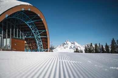Moderne Bergstation in Filzmoos vor präparierter Piste mit Blick auf die Bischofsmütze | © filzmoos.ski