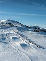 Drone image of a piste landscape with snow jumps