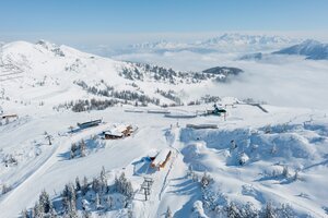 Verschneites Skigebiet Shuttleberg mit Liften, Hütten und Bergkulisse bei klarem, sonnigem Wetter | © Shuttleberg