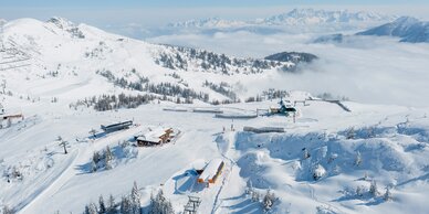 Snowy Shuttleberg ski area with lifts, huts and mountain scenery in clear and sunny weather | © Shuttleberg