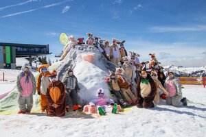 Gruppe verkleideter Skifahrer als Osterhasen posiert auf Schneehügel bei Sonnenschein im Skigebiet | © Shuttleberg