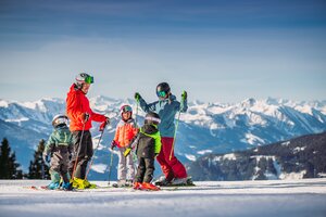 Eine fünfköpfige Familie steht auf der Piste im Skigebiet Monte Popolo in Eben. 