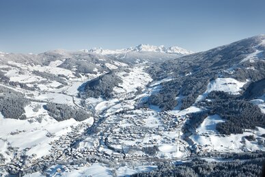 Verschneite Flugaufnahme von Wagrain, Tal mit Häusern, Bäumen und Bergen | © Snow Space Salzburg