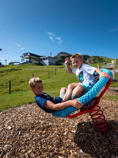 Zwei Kinder schaukeln auf Seilspielgerät bei der Gamskogelbahn Zauchensee im Sommer. | © Zauchensee Liftgesellschaft