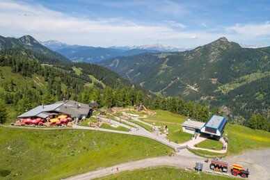 Sommerliche Aussicht auf Gamskogelhütte mit Spielplatz, Gondelstation und Bergen im Hintergrund | © Zauchensee Liftgesellschaft