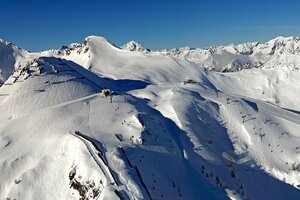 Panoramablick vom Gamskogel mit Skipisten, Liften und verschneiten Bergen im Hintergrund
