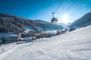 Gondelbahn im Zauchensee Tal mit verschneiten Hängen, Pulverschnee und Sonne im Hintergrund