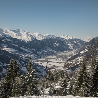 Aussicht in ein verschneites Tal, dass links und rechts von den Bergen eingesäumt ist | © Georg Roske
