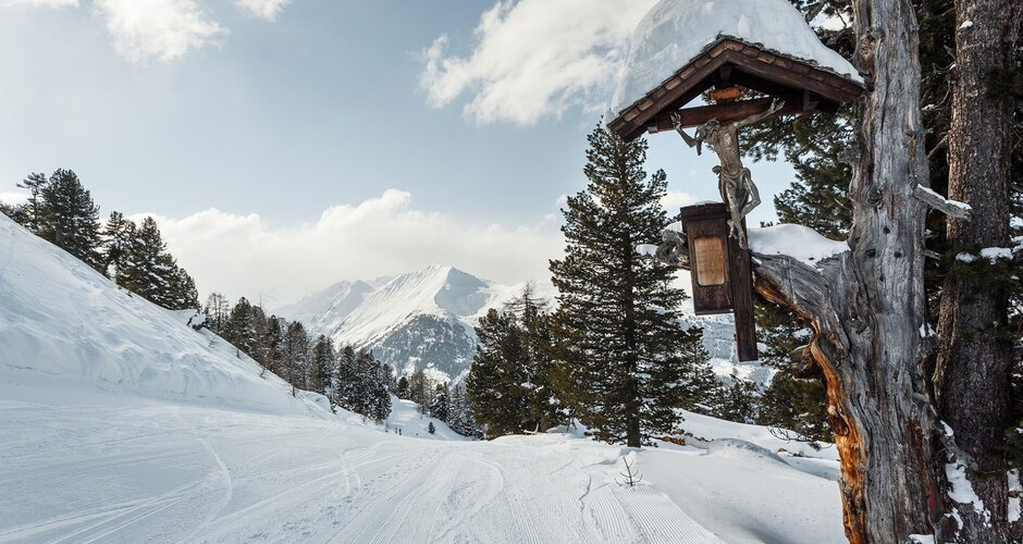 Präparierte Piste und links steht ein Baum an dem ein Marterl befestigt ist | © Georg Roske