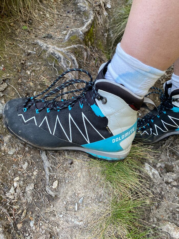 Sure-Footed Hiking: Trekking Shoe on Root-Covered Trail Close-up of a Dolomite hiking boot on a rooty, rocky trail – symbol of secure footing and proper gear in alpine terrain.