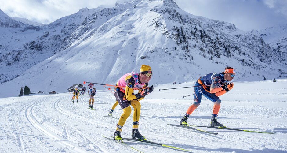 Spitzengruppe der Gastein Classics beim Langlauf im Pulverschnee | © Gasteinertal Tourismus, Christoph Oberschneider Zwei Langläufer führen ein Rennen im Sonnenschein durch verschneite Berglandschaft in Gastein an. | © Gasteinertal Tourismus, Christoph Oberschneider