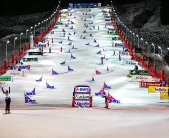 Beleuchtete Parallel-Slalom-Strecke mit Snowboardern beim Weltcup in Gastein am Abend im Zielbereich. | © Stefan Lauterbach