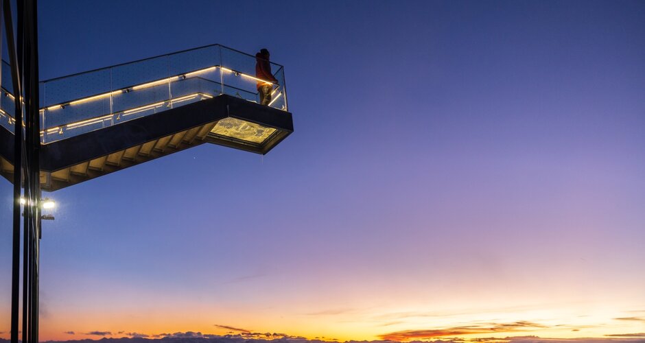 Person steht auf der beleuchteten Himmelsleiter am Dachstein bei farbenprächtigem Sonnenuntergan | © Martin Huber