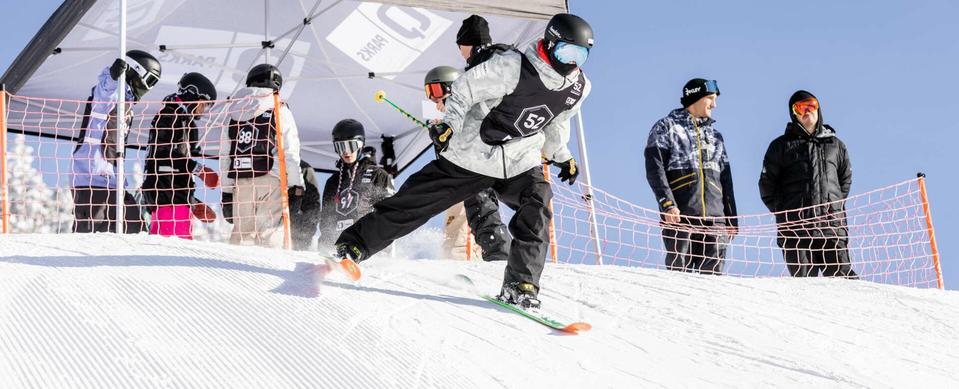 Freestyle-Skifahrer fährt vom Start weg und unter dem Zelt, dass beim Start steht sind schon die nächsten Teilnehmer versammelt | © Hannes Mautner