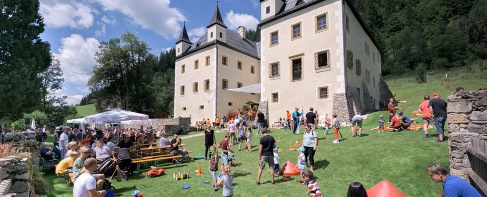 Viele Familien spielen und feiern bei sonnigem Wetter vor Schloss Höch | © Flachau Tourismus