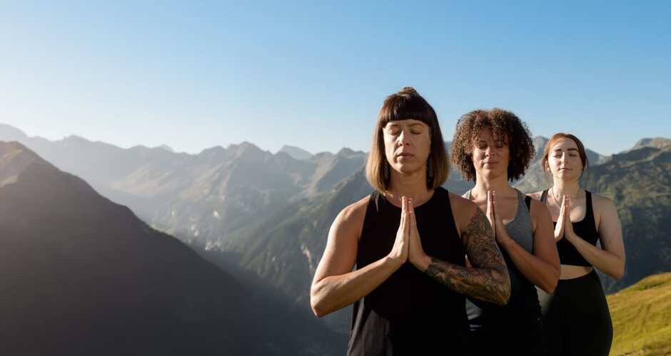 Drei Frauen stehen hintereinander und haben die Hände vor sich gefaltet und im Hintergrund ist ein schönes Bergpanorama zu sehen | © Gasteinertal Tourismus GmbH, Markt Photography