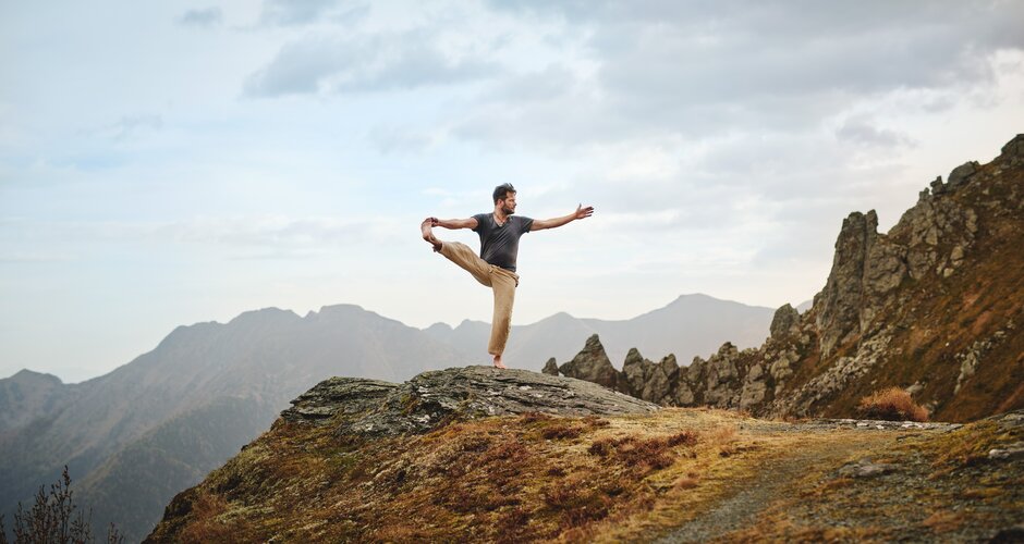 Mann steh in einer Yoga-Pose auf einem Fels | © Gasteinertal Tourismus GmbH, Michael Königshofer