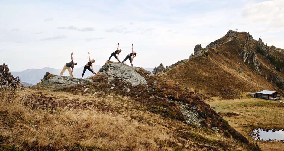 4 Personen stehen auf einem Fels und machen Yoga | © Gasteinertal Tourismus GmbH, Michael Königshofer