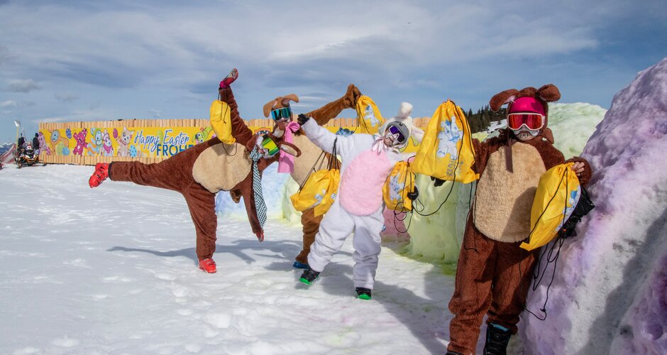 Vier verkleidete Personen als Osterhasen mit gelben Goodie-Bags auf bunt gefärbtem Schnee | © Shuttleberg