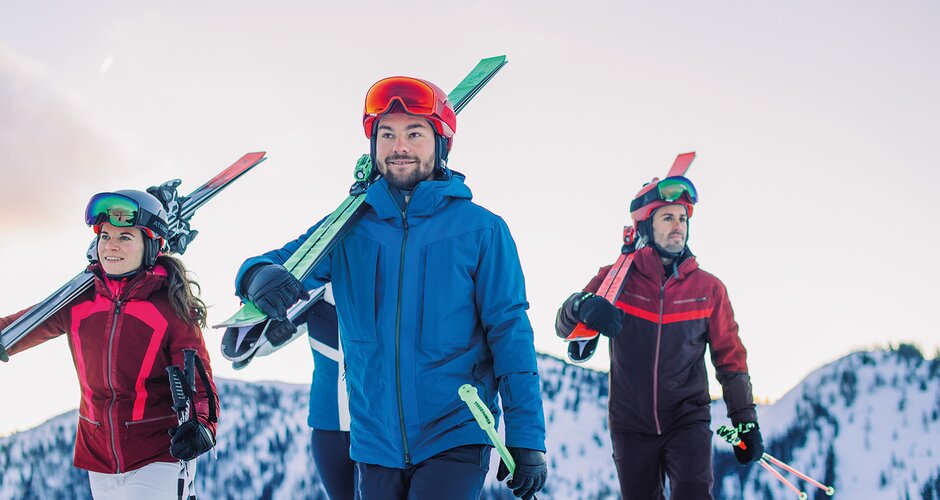Vier Skifahrer tragen ihre Ski auf der Schulter – idealer Start für den Skikurs Back2Ski, ein Kurs für Wiedereinsteiger. | © Ski amadé