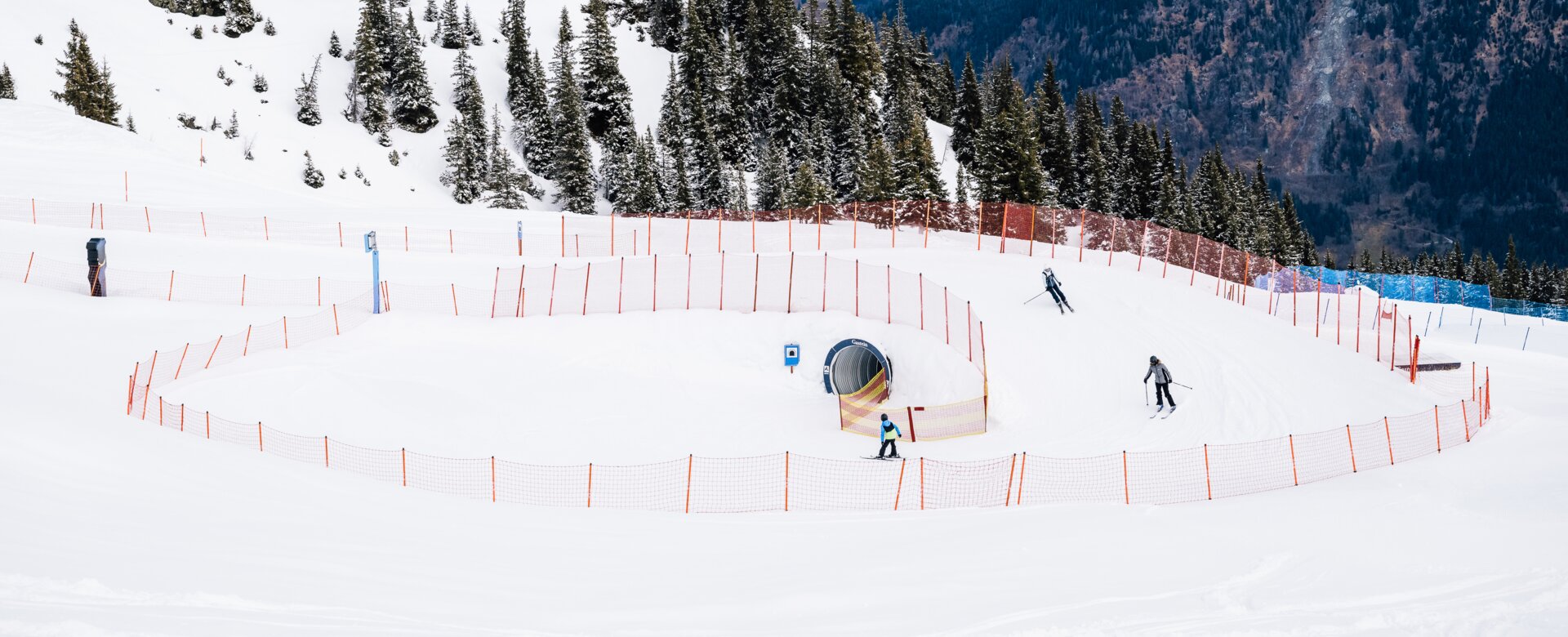 Skifahrer auf der Funline mit Schneetunnel und Kurven in verschneiter Berglandschaft | © Christian Riefenberg | QParks