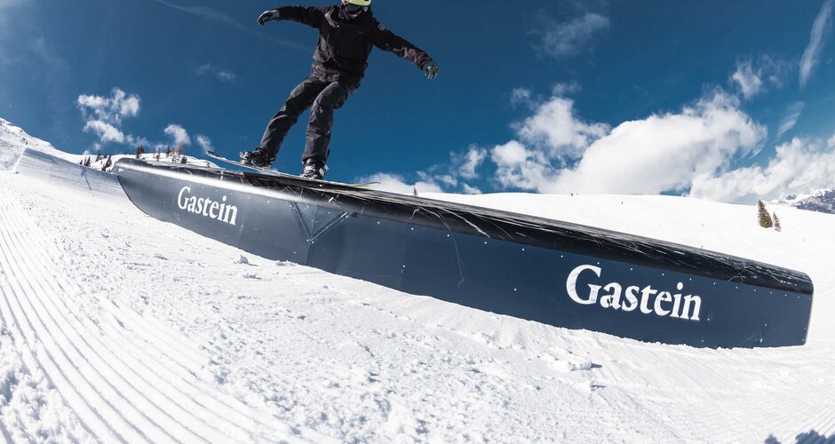 Snowboader in schwarzen Skianzug gleitet über ein Hindernis im Snowpark | © Q-Parks Hannes Mautner