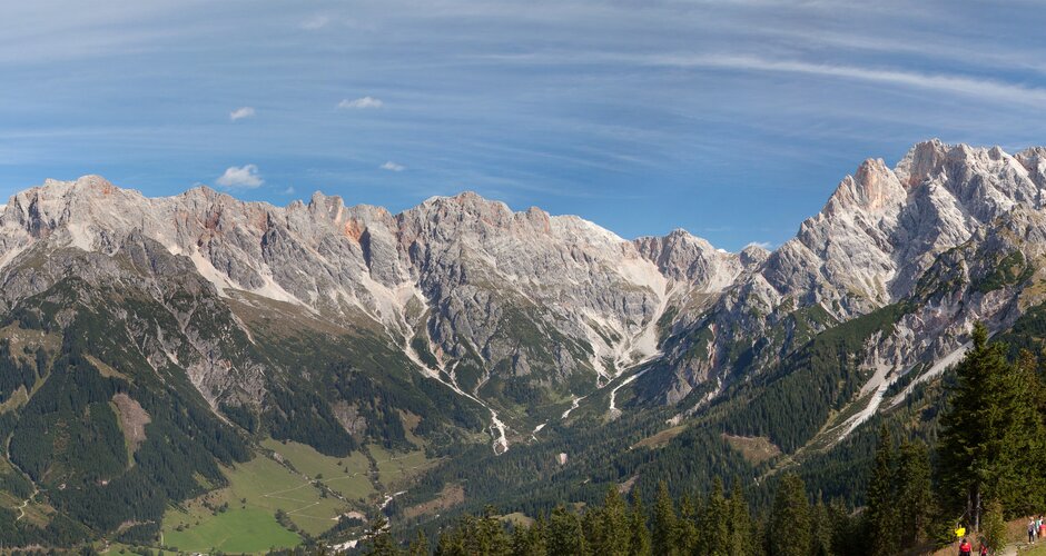 Weitläufiger Blick über das Steinerne Meer mit Herbstwald, Bergsee und Zaun im Vordergrund, Panoramaaufnahme bei klarem Himmel.