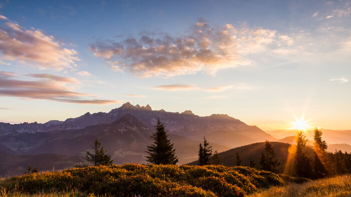 Sonnenaufgang in Filzmoos im Spätsommer | © Coen Weesjes Die Sonne geht auf und taucht Wälder und Almen in goldenes Licht unter leicht bewölktem Himmel. | © Coen Weesjes