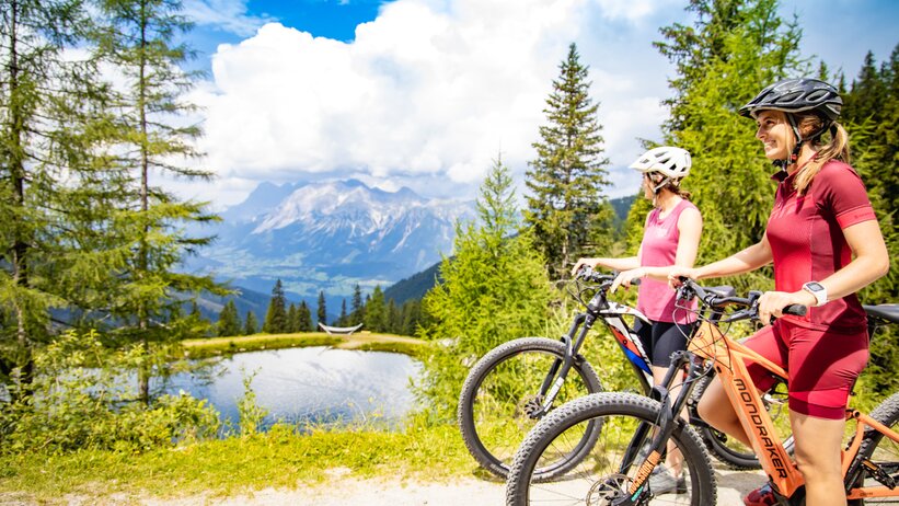 Zwei Frauen mit Mountainbikes genießen die Aussicht am Bergsee | © Hauser Kaibling