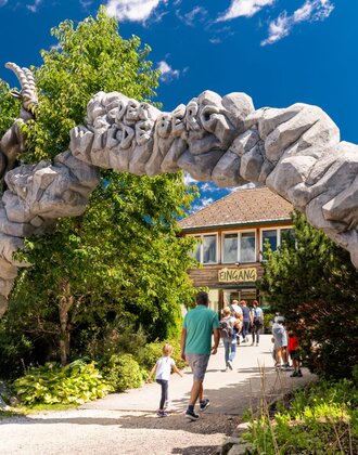 Visitors walk through the stone entrance gate to Wilde Berg in Mautern with animal figures. | © Christine Höflehner