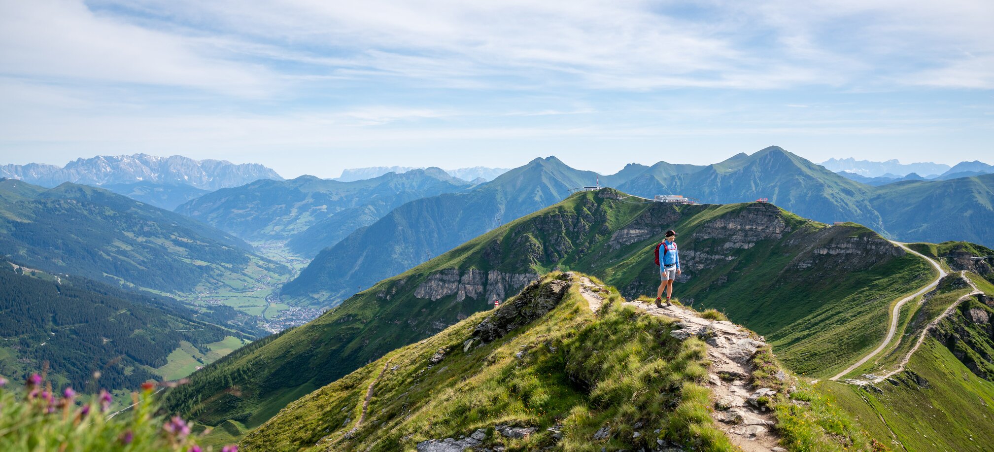 Hiker on a ridge trail at Stubnerkogel with a wide view over the green Gastein Valley and the surrounding mountain peaks | © Gasteinertal Tourismus GmbH, Christoph Oberschneider