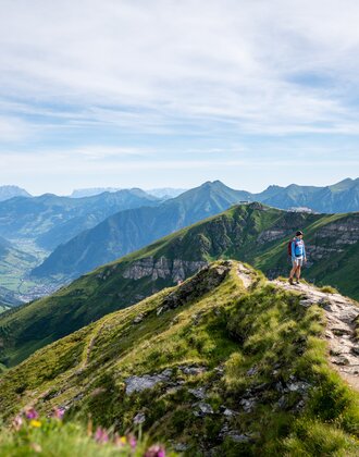 Wanderer auf einem Gratweg am Stubnerkogel mit weitem Blick über das grüne Gasteinertal und die umliegenden Berggipfel | © Gasteinertal Tourismus GmbH, Christoph Oberschneider