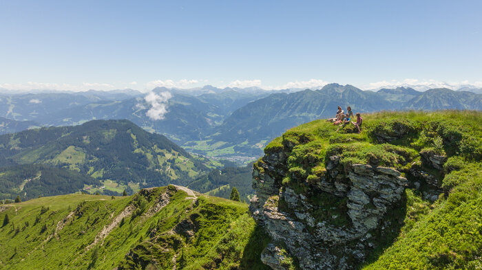 Wandern in der Region Hochkönig | © Roland Haschka Familie sitzt auf einem Felsvorsprung und rundherum sind hohe Berge zu sehen | © Roland Haschka