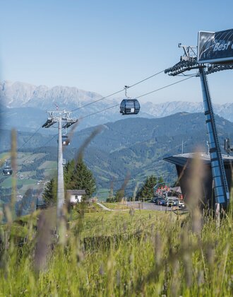 Sommerliche Gondelfahrt mit der Flying Mozart Bahn in Wagrain, Panoramablick über Täler, Wiesen und Berge bei klarem Himmel | © Snow Space Salzburg - Christian Schartner